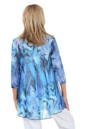 Woman wearing a blue patterned cardigan on a white background. Back shot.