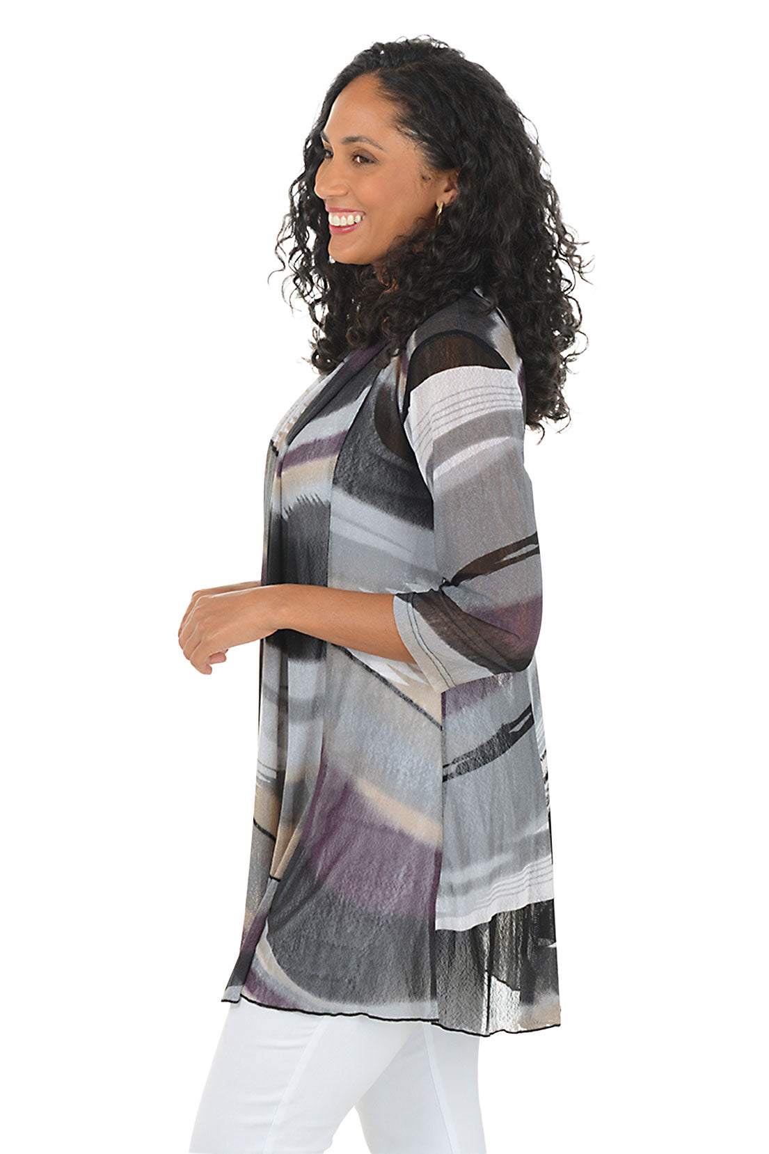 Woman wearing a patterned cardigan over a white top on a white background. Side shot.