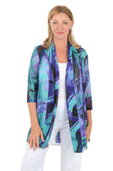 Woman wearing a colorful cardigan with a white background.