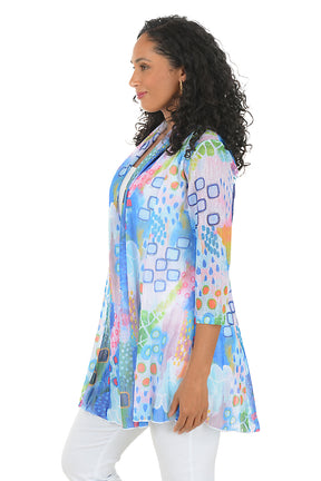Woman wearing a colorful patterned jacket on a white background. Side shot.