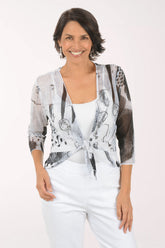 Woman wearing a patterned cardigan over a white top and pants on a white background