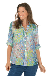 Woman wearing a colorful patterned shirt on a white background.