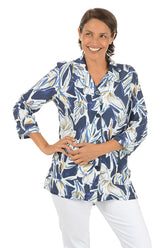 Woman wearing a blue floral patterned blouse on a white background.