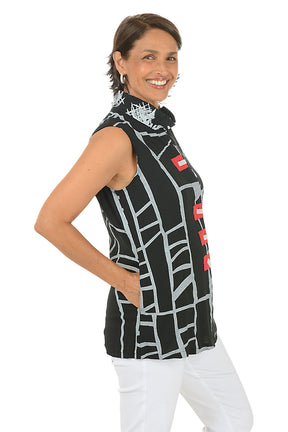 Woman wearing a sleeveless black top with white and red patterns on a white background. Side shot.