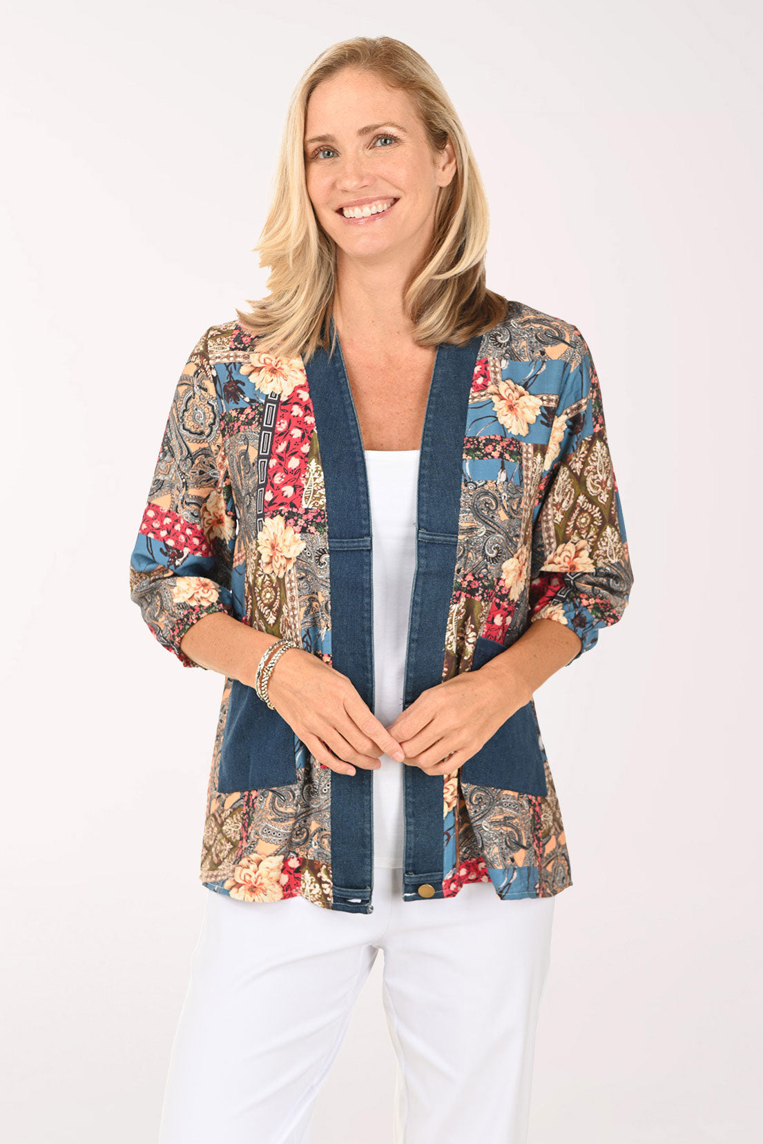 Woman wearing an open front multi colored top with a denim trim
