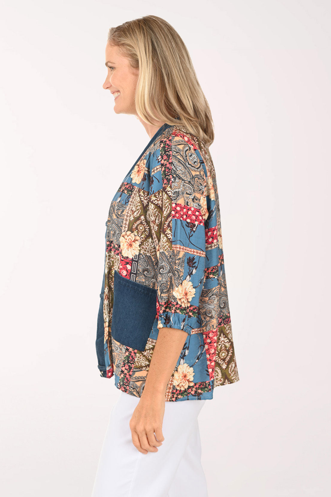 Woman wearing an open front multi colored top with a denim trim
