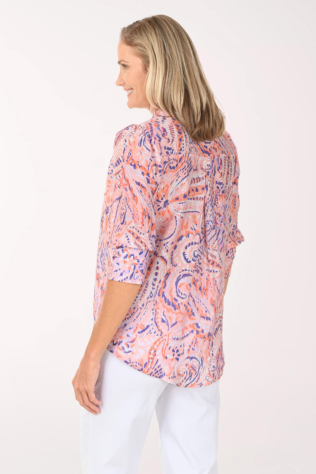 Woman wearing a 3/4 sleeve pink paisley top