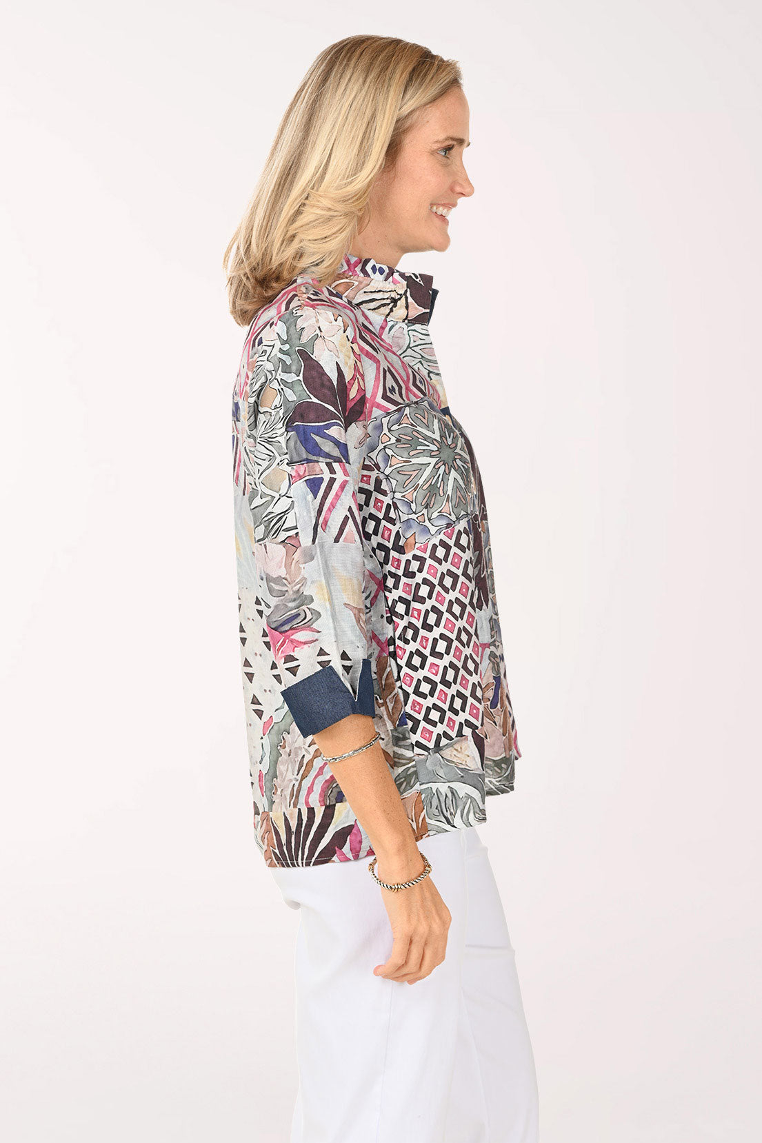 Woman wearing a multi colored button down top with 3/4 sleeves