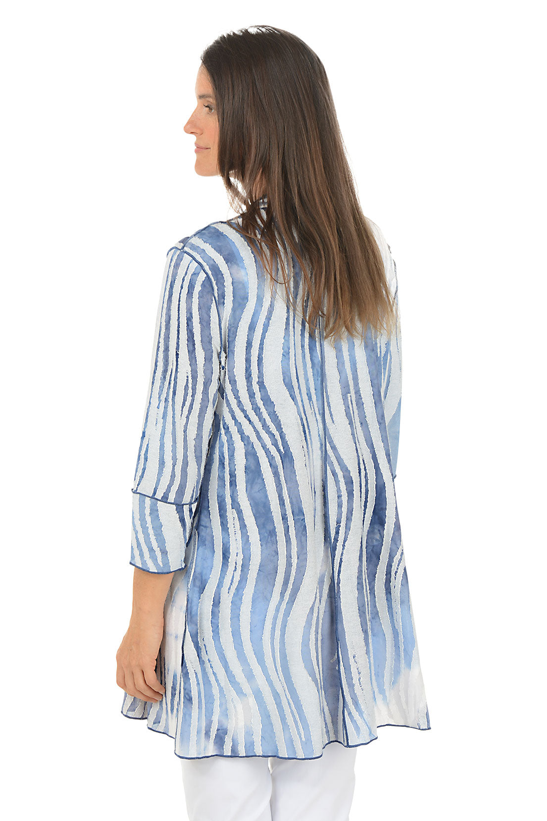 Woman wearing a blue and white tie-dye shirt on a white background. Back shot. 