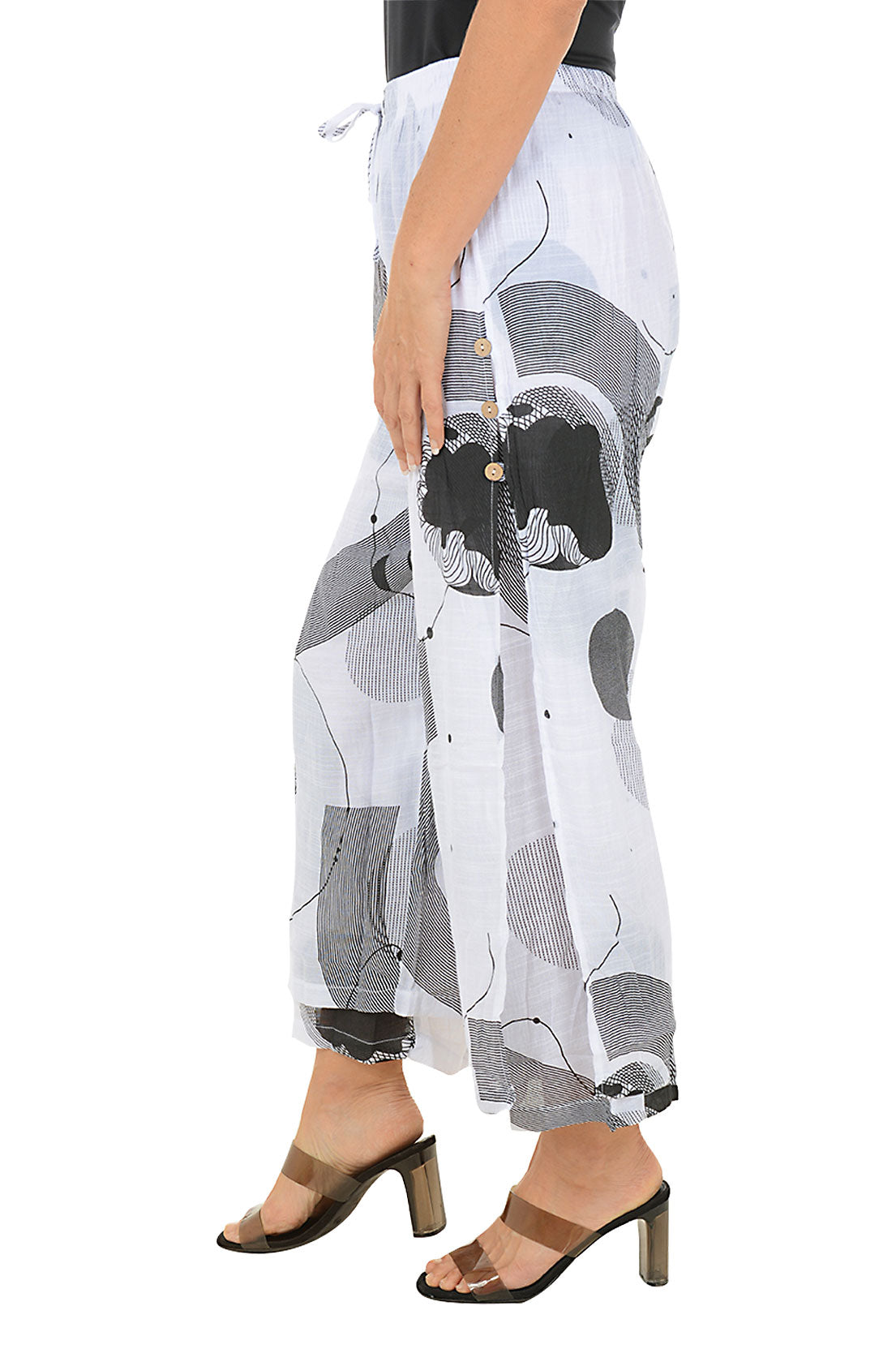White pants with black and gray geometric pattern worn by a person on a white background. Side shot.