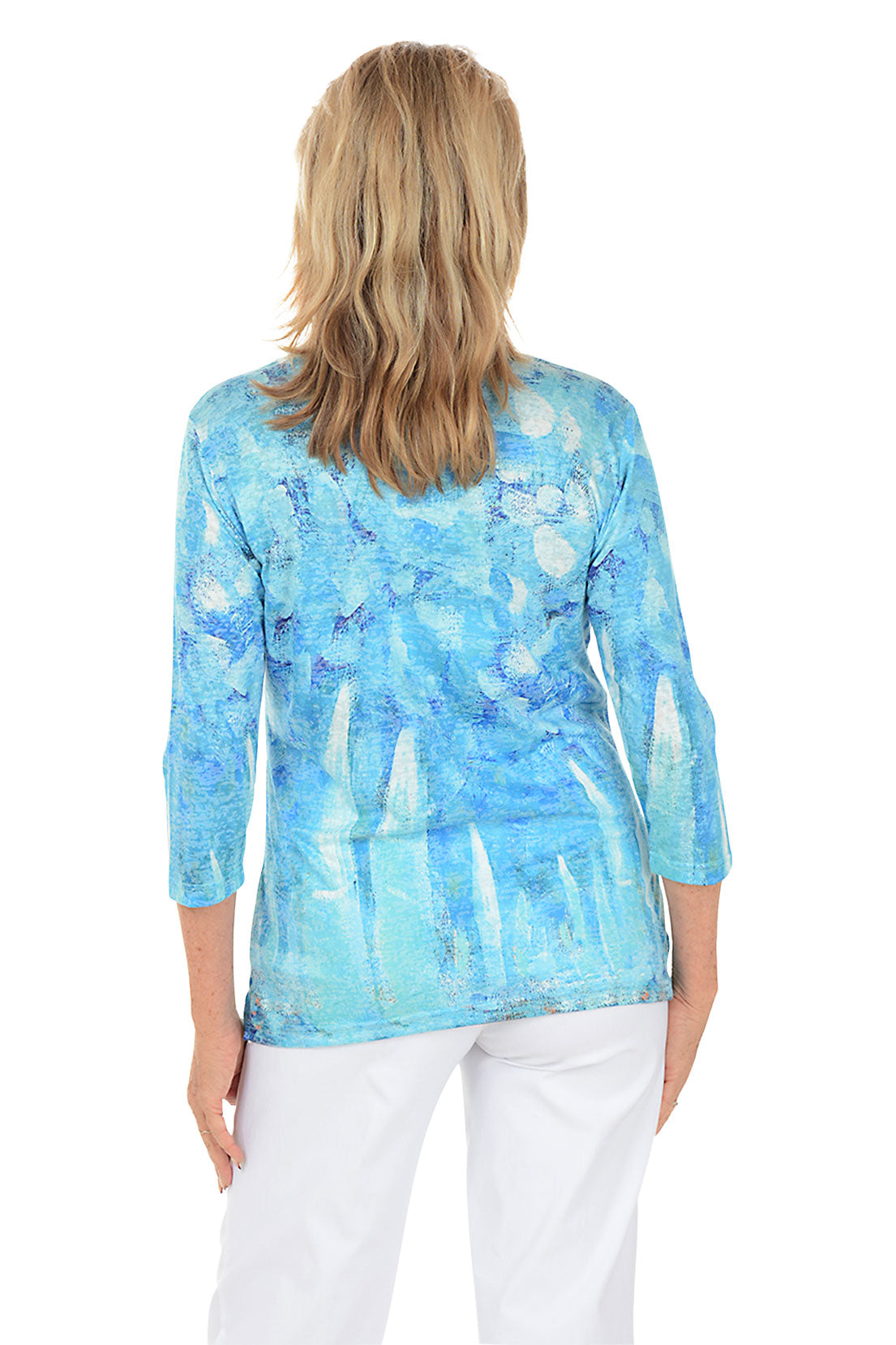 Woman wearing a blue patterned top on a white background. Back shot.