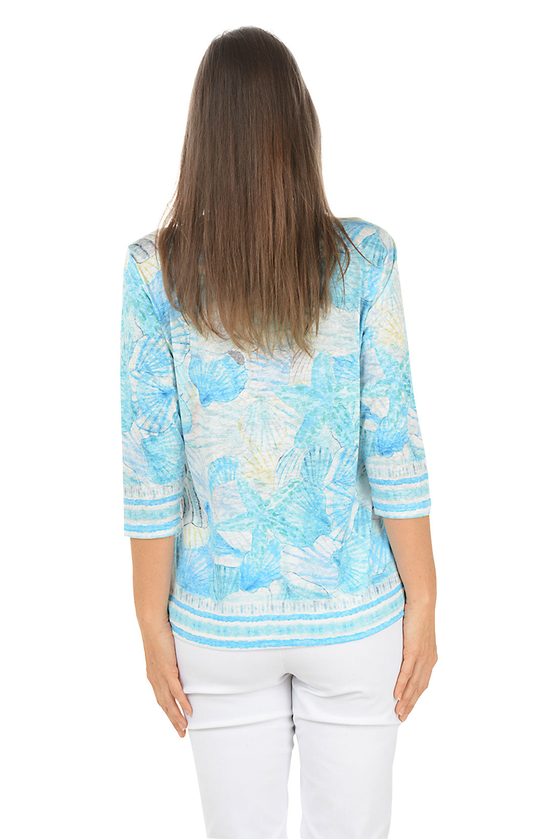 Woman wearing a blue patterned top on a white background. Back shot.