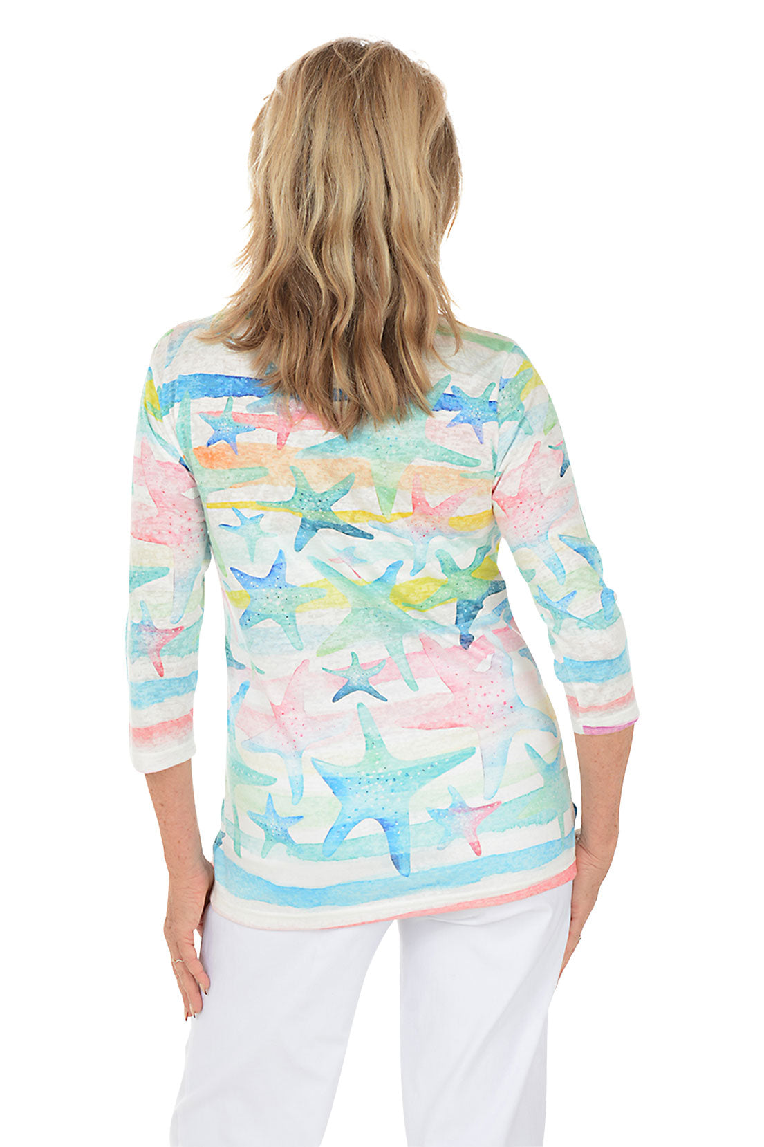 Woman wearing a colorful starfish-patterned top on a white background. Back shot.