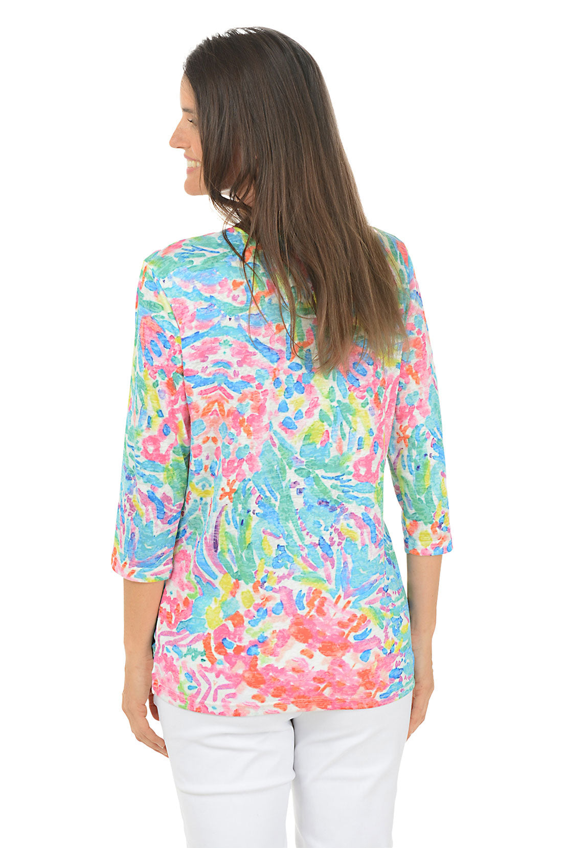 Woman wearing a colorful patterned top on a white background. Back shot.