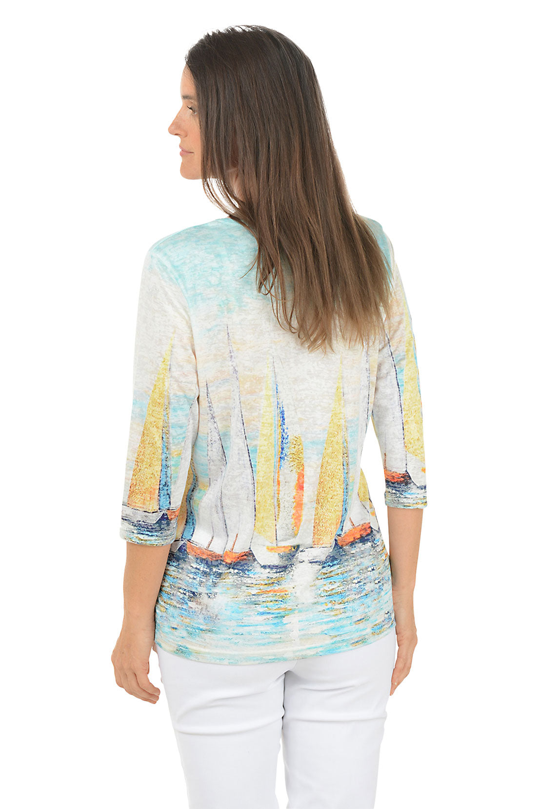 Woman wearing a colorful sailboat print top on a white background. Back shot.