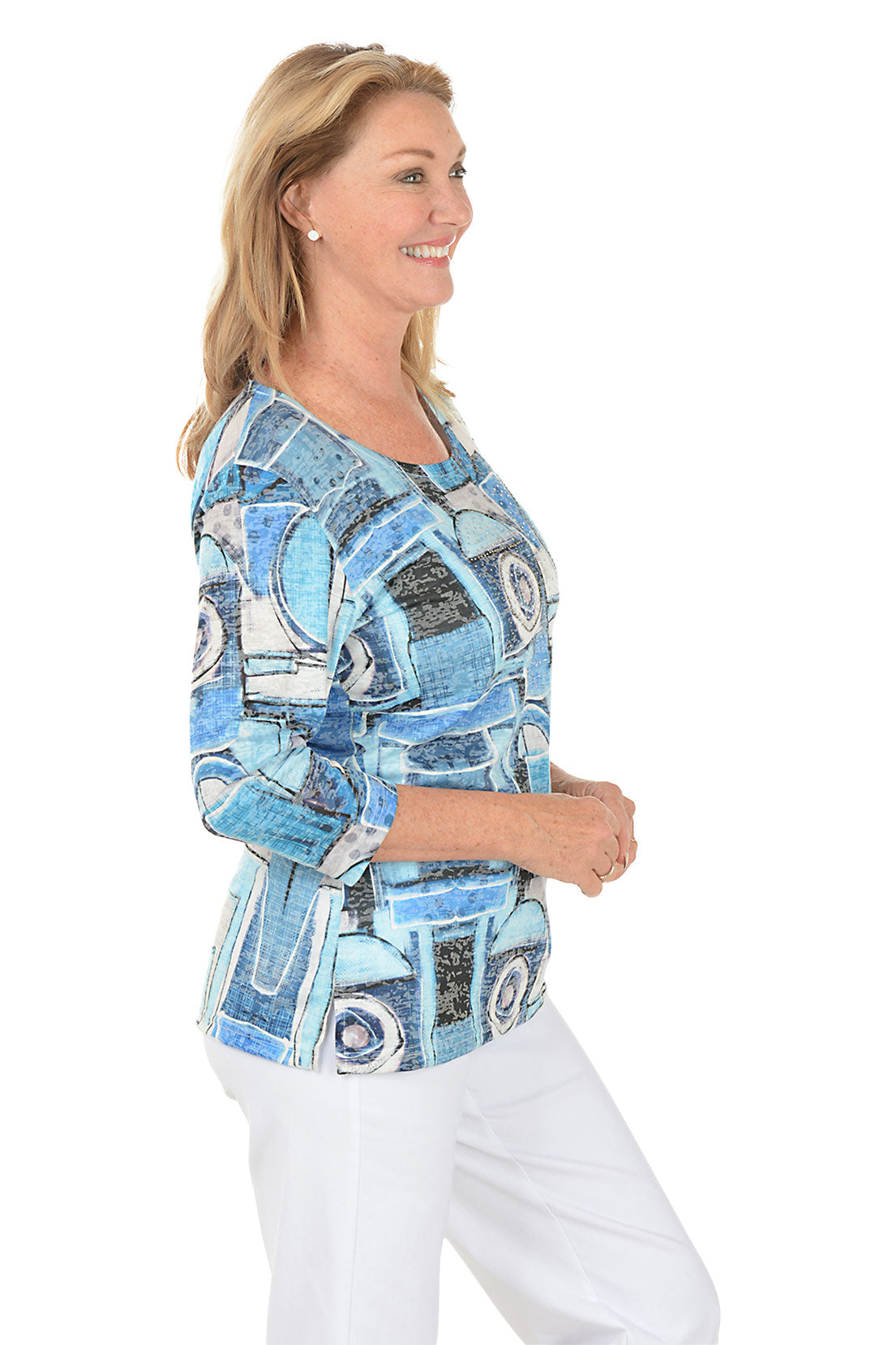 Woman wearing a blue abstract patterned top on a white background. Side shot.