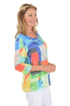 Woman wearing a colorful patchwork sweater on a white background. Side shot.