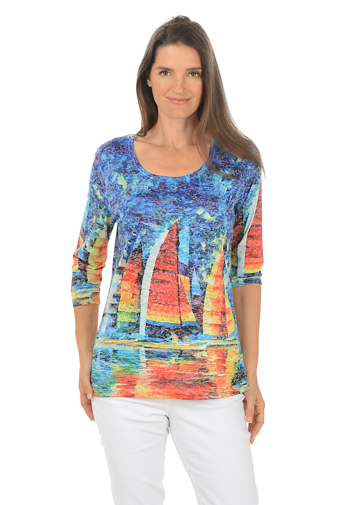 Woman wearing a colorful sailboat print top on a white background.
