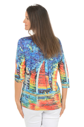 Woman wearing a colorful sailboat print top on a white background. Back shot.