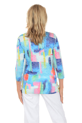 Woman wearing a colorful abstract patterned top on a white background. Back shot.