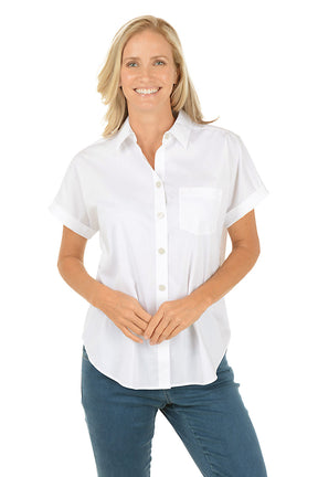 Woman wearing a white button-up shirt and blue jeans on a white background.