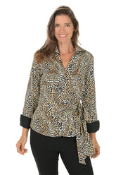 A woman wearing a leopard patterned blouse with a collar and side tie.
