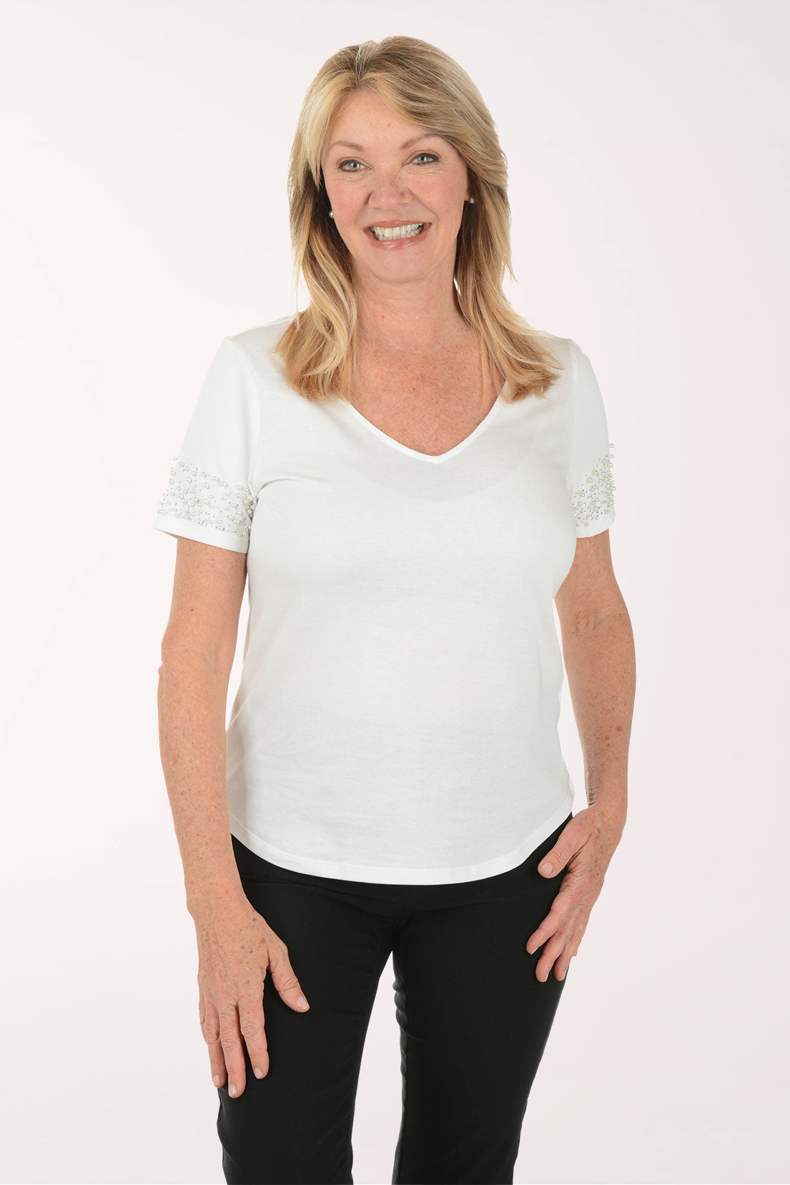 Woman wearing a white blouse with lace details on a white background