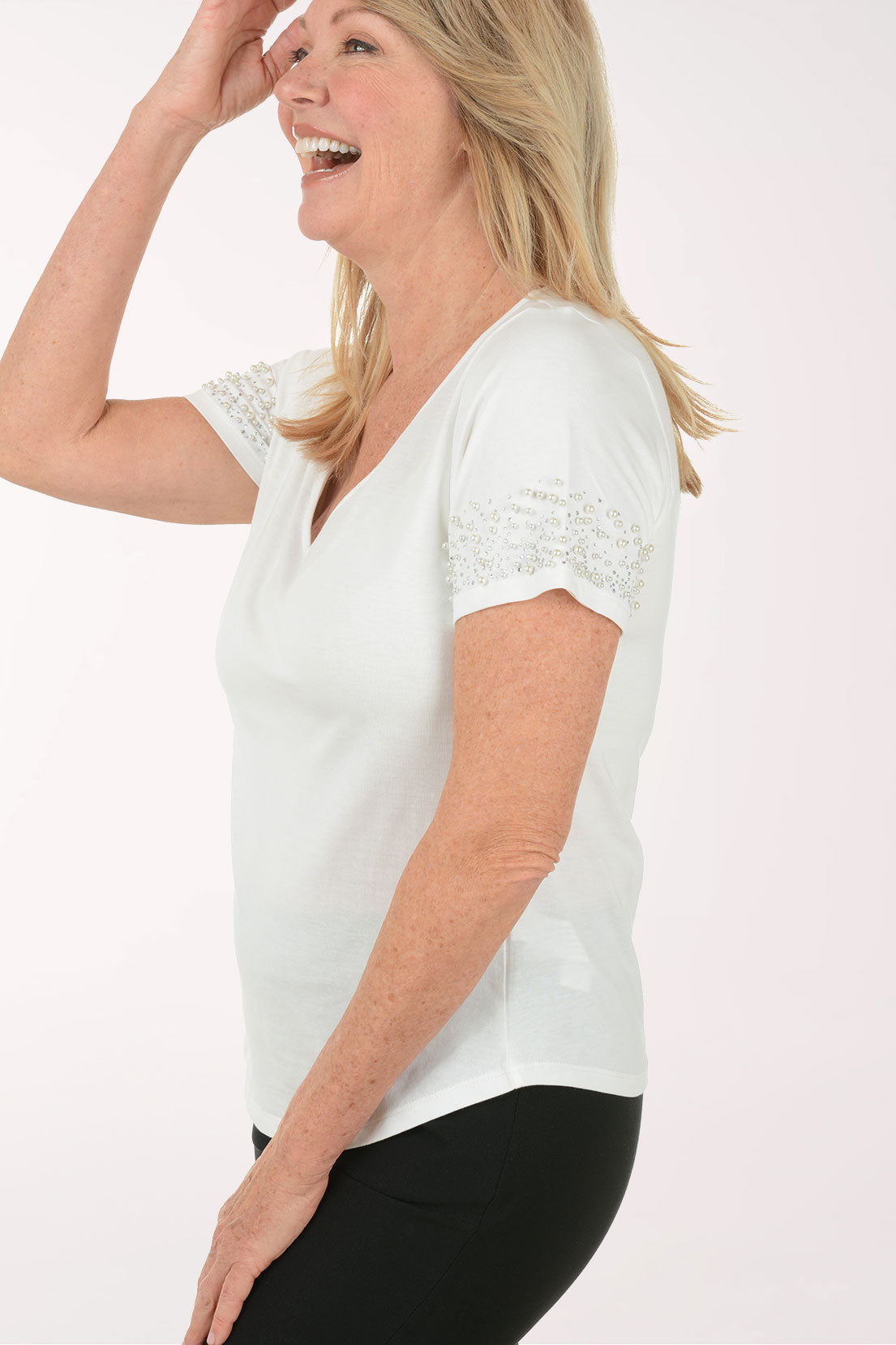 Woman wearing a white blouse with lace details on a white background