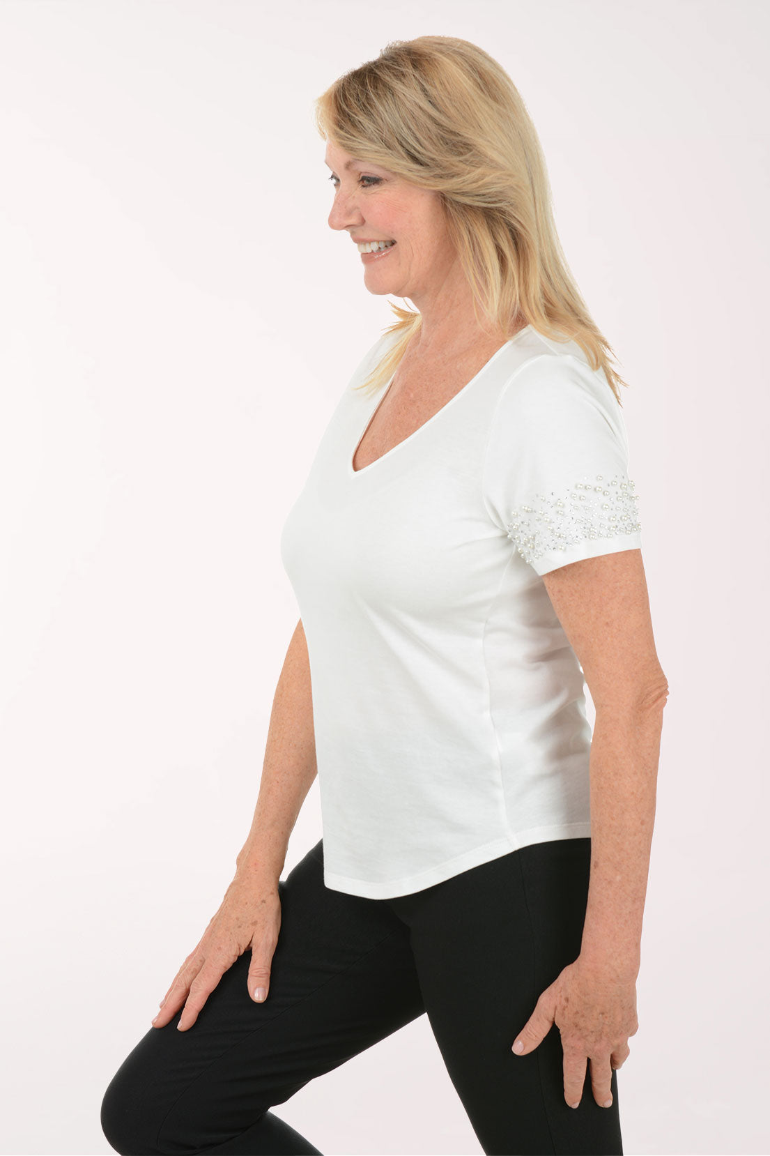 Woman wearing a white blouse with lace details on a white background