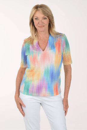 Woman wearing a colorful tie-dye shirt on a white background