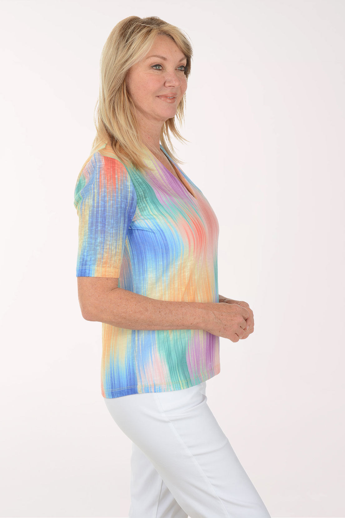 Woman wearing a colorful tie-dye shirt on a white background