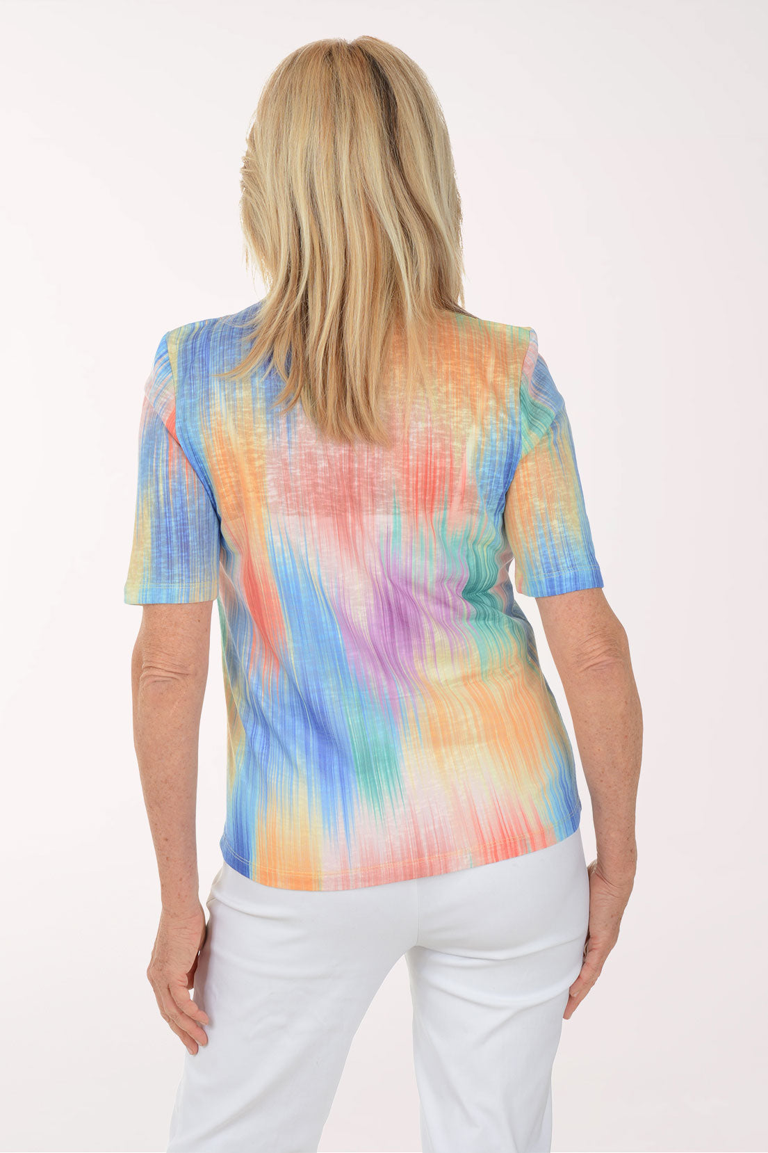 Woman wearing a colorful tie-dye shirt on a white background