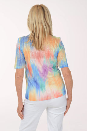 Woman wearing a colorful tie-dye shirt on a white background