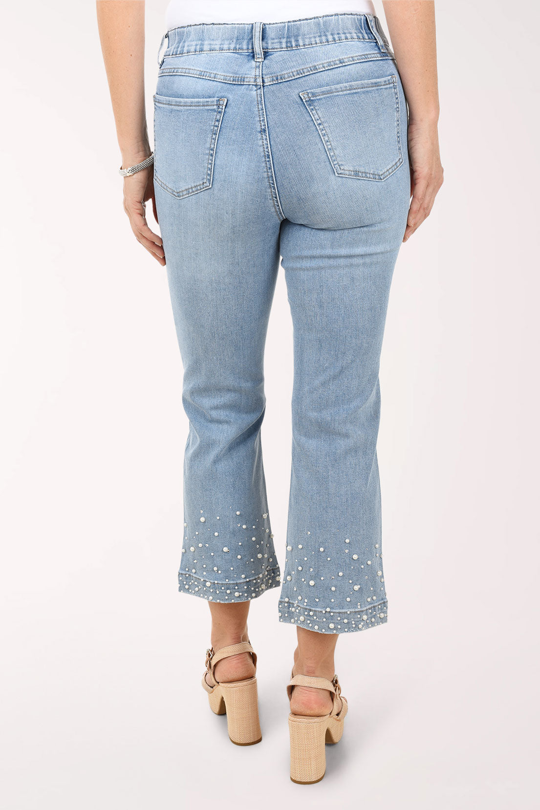 Light blue jeans worn by a person on a white background