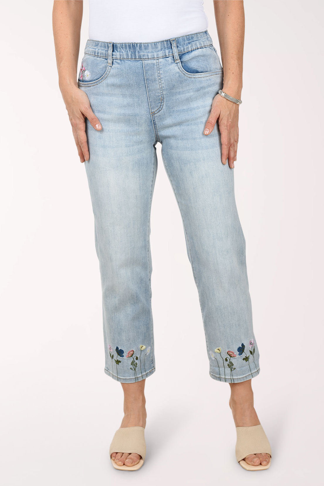 Light blue jeans with floral embroidery on a white background