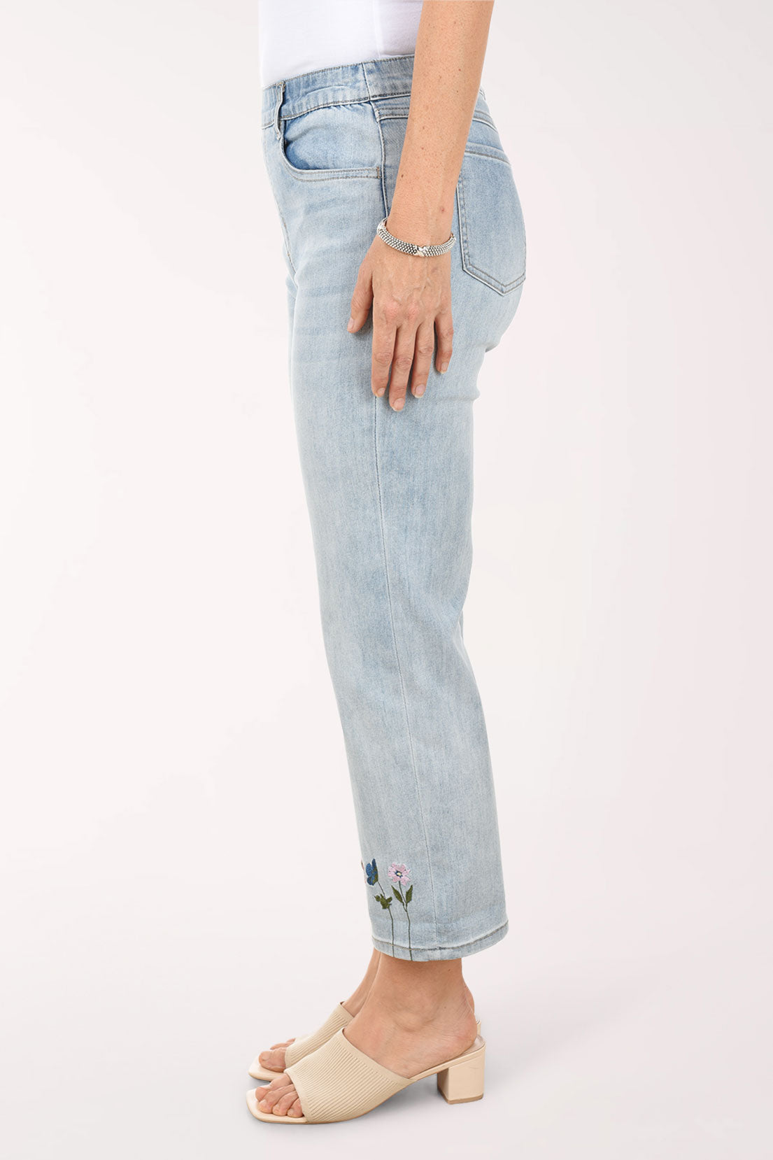 Light blue jeans with floral embroidery on a white background