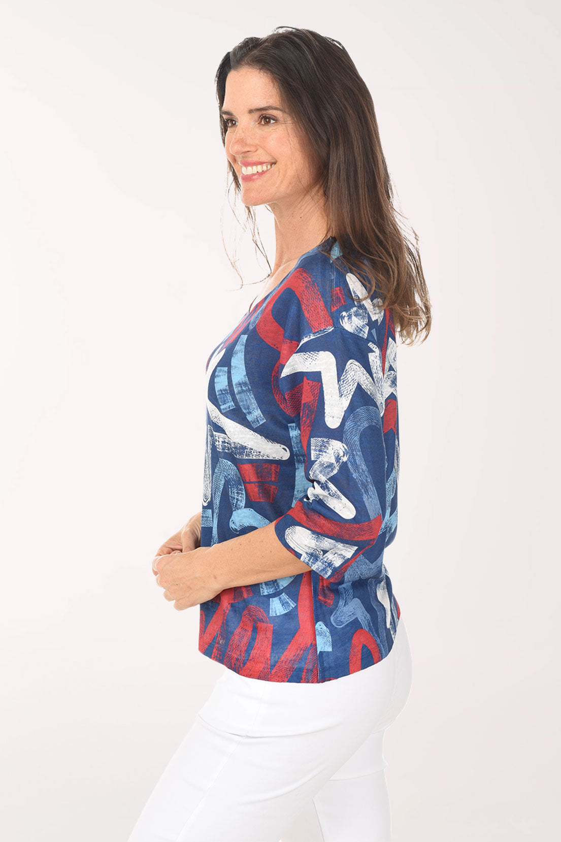 Woman wearing a colorful star-patterned top on a white background