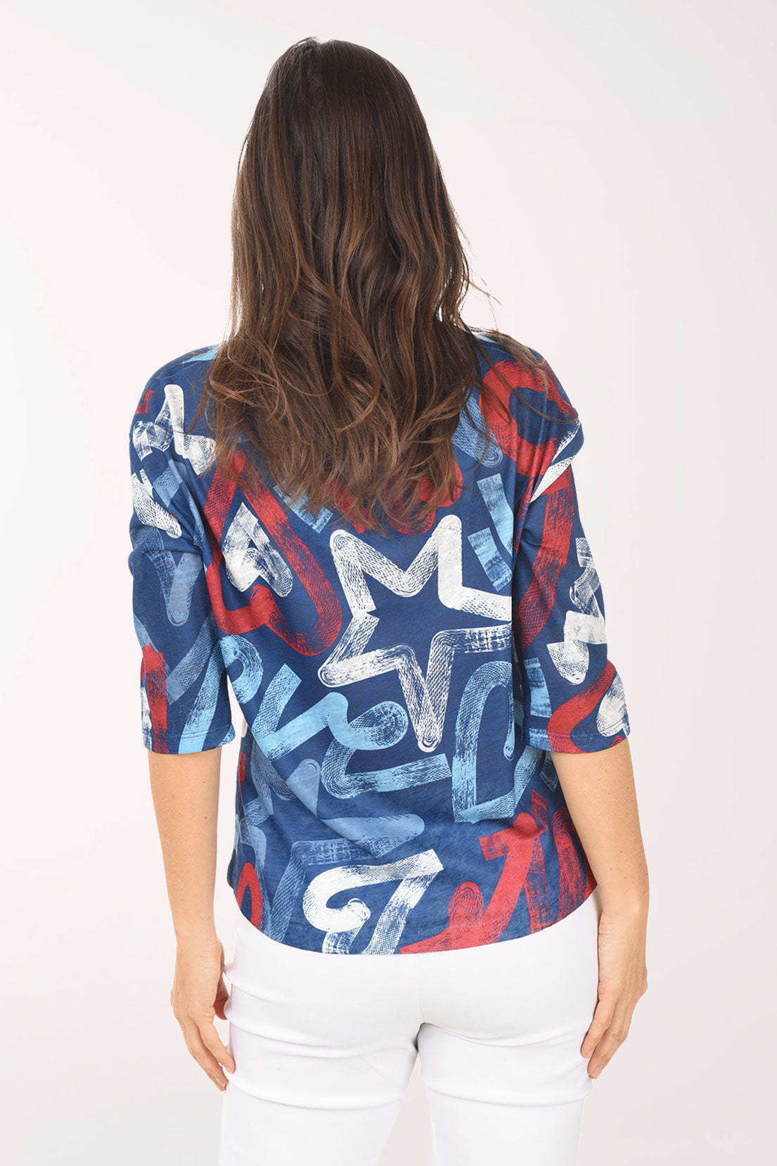 Woman wearing a colorful star-patterned top on a white background