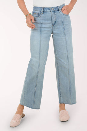 Woman wearing a striped sweater and light blue jeans on a white background