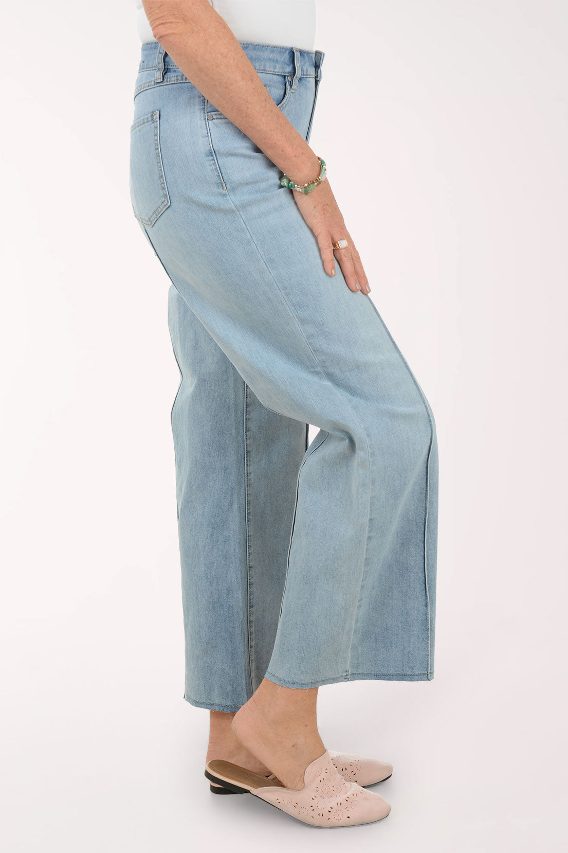 Woman wearing a striped sweater and light blue jeans on a white background