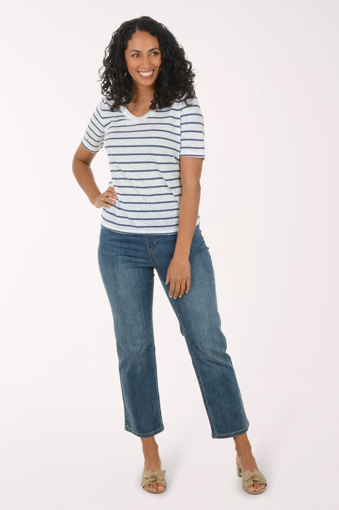 Woman wearing a striped shirt and jeans on a white background