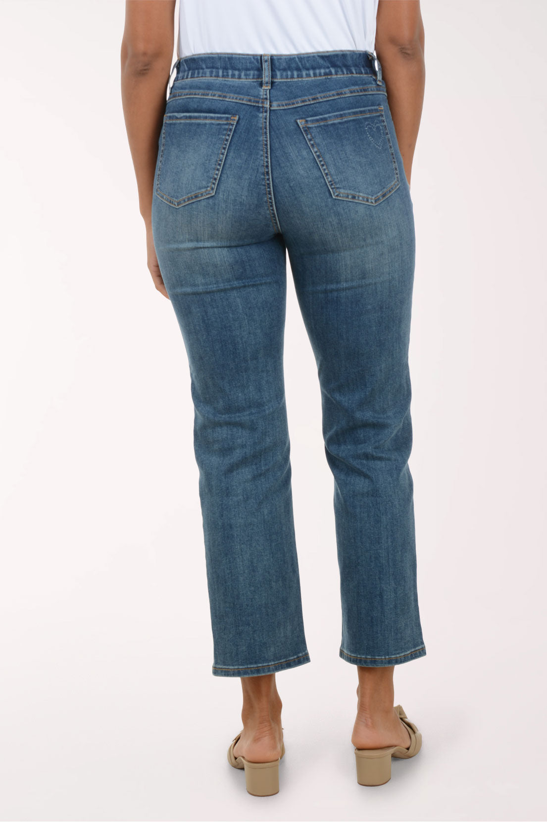 Person wearing blue jeans on a white background