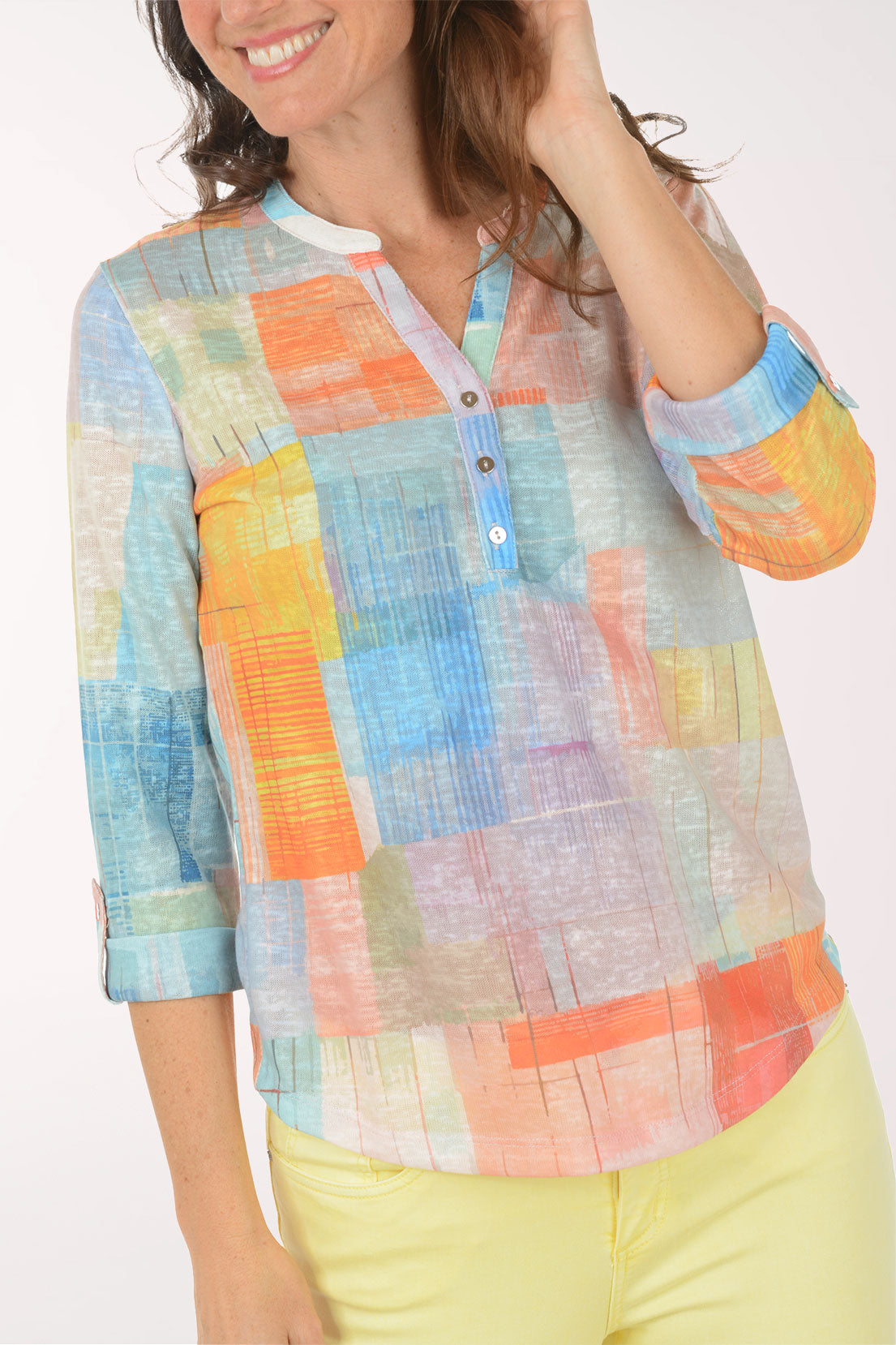 A woman wearing a multicolored plaid 3/4 sleeve top.