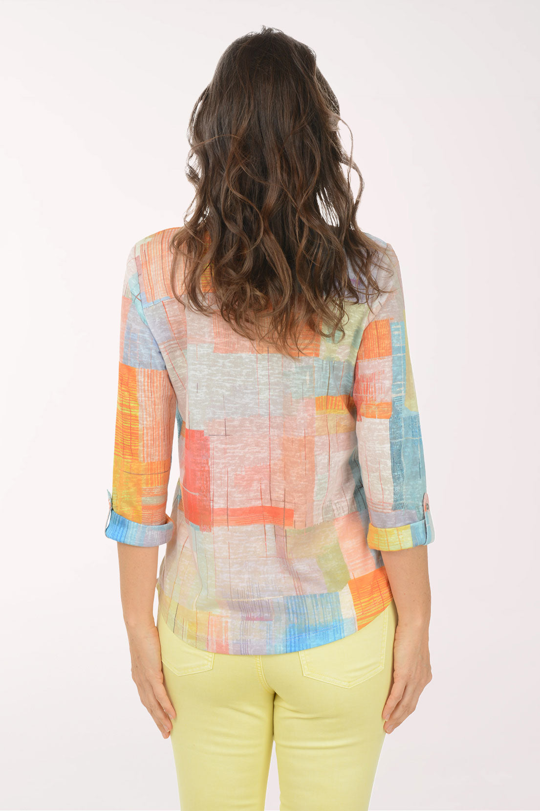 A woman wearing a multicolored plaid 3/4 sleeve top.