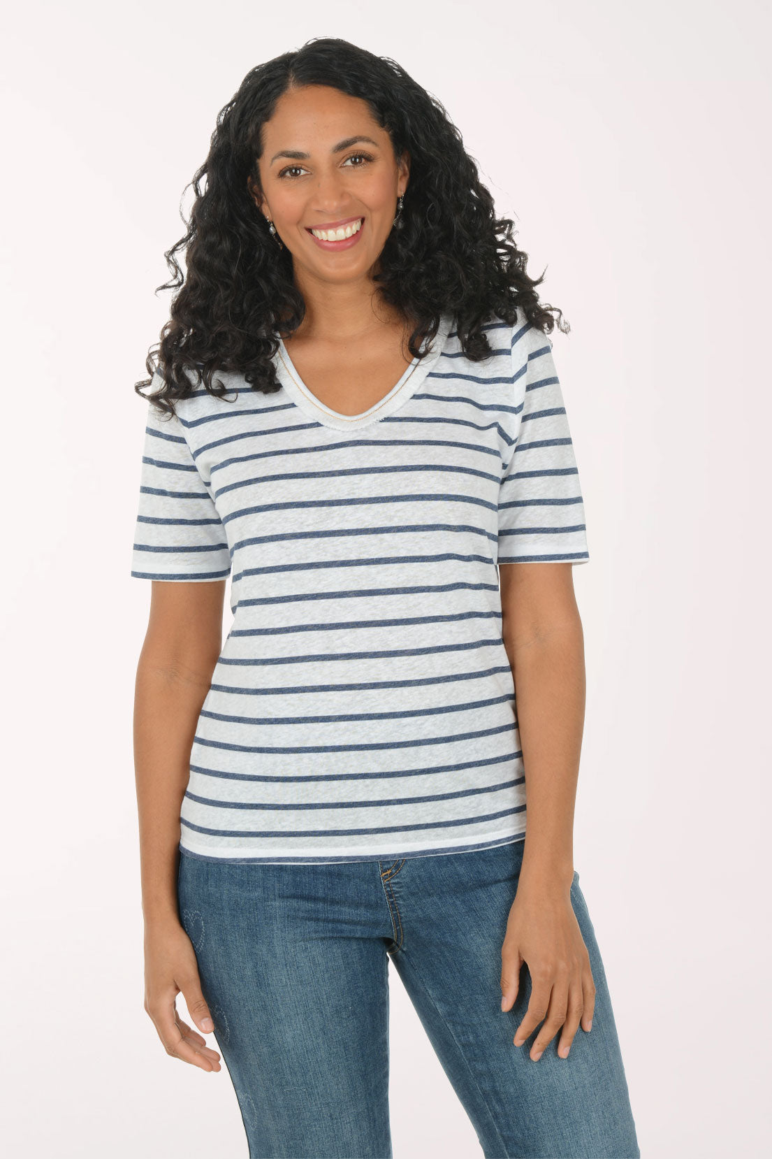 Woman wearing a striped shirt and jeans on a white background