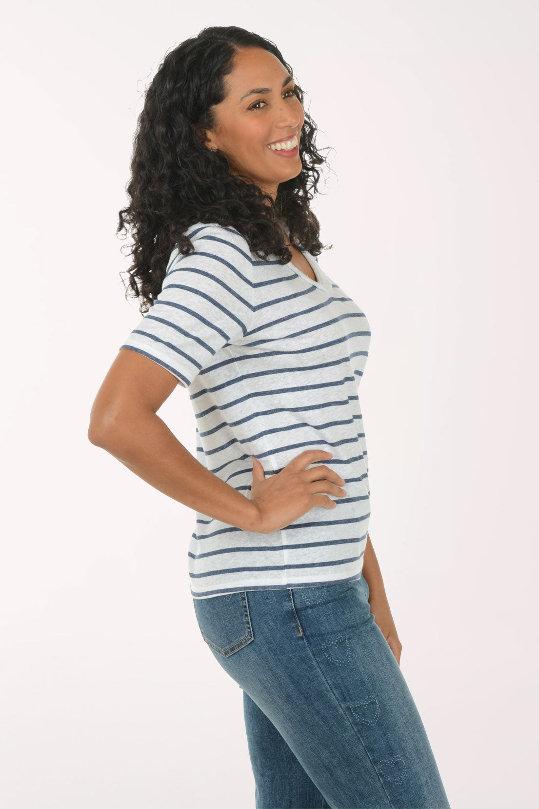 Woman wearing a striped shirt and jeans on a white background