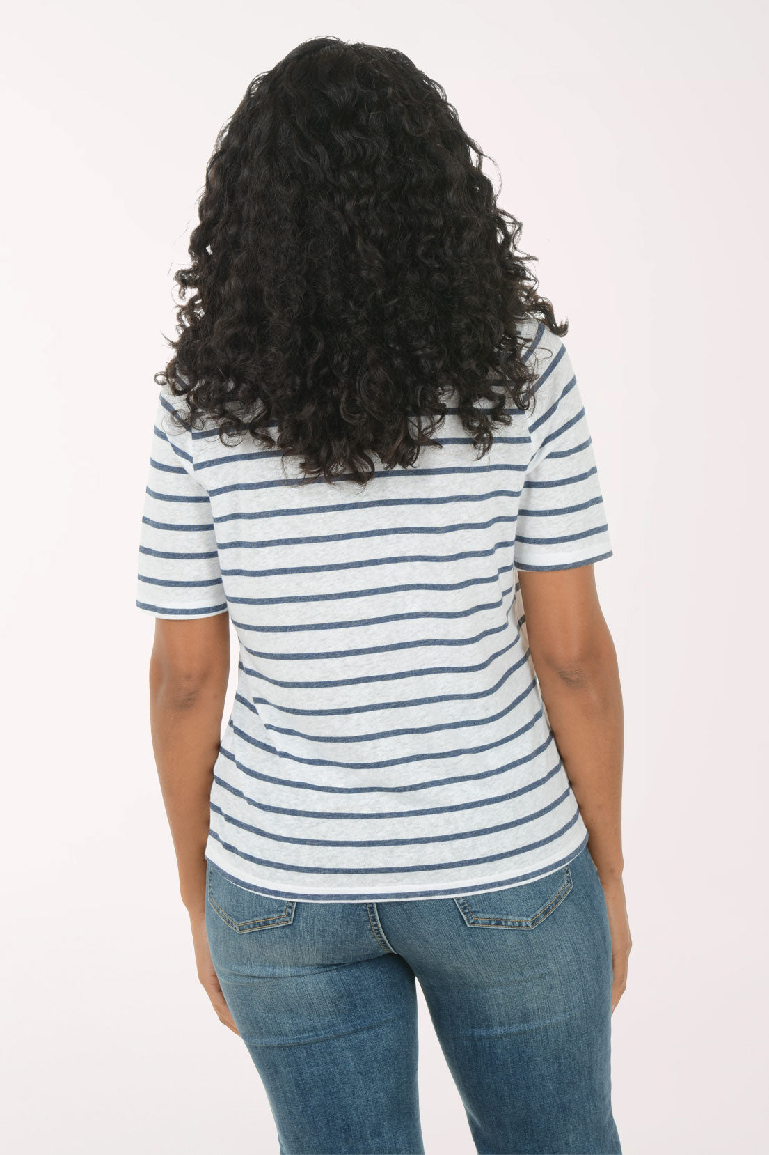 Woman wearing a striped shirt and jeans on a white background