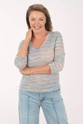 Woman wearing a striped sweater and jeans on a white background
