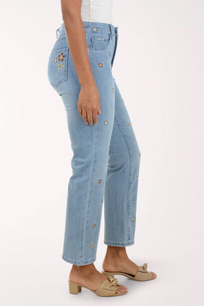 Light blue jeans with floral embroidery on a white background