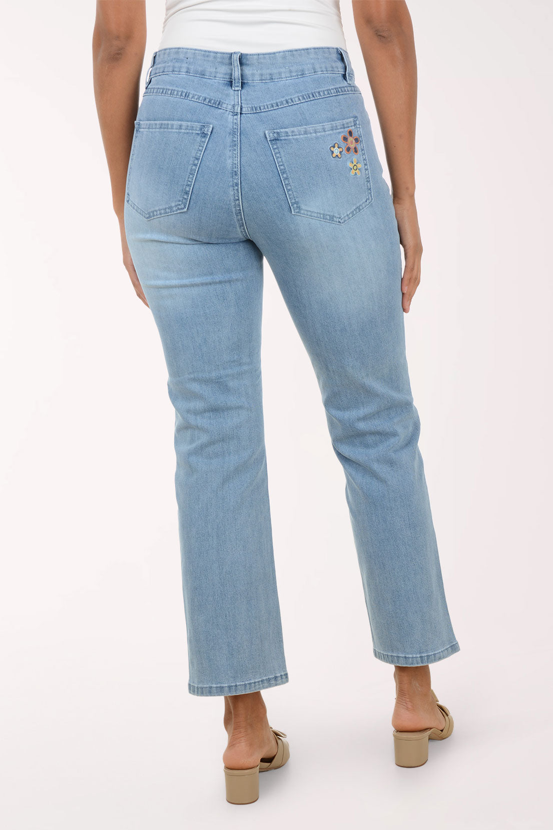 Light blue jeans with floral embroidery on a white background